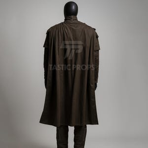 May include: A brown costume with a long cape and matching pants. The costume is displayed on a mannequin. The text "TASTIC PROPS" is printed on the cape.