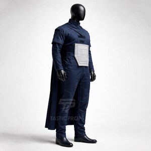 May include: A dark blue costume with a cape, long sleeves, and a high collar is displayed on a mannequin. The costume includes a gray chest piece and is paired with black gloves and boots. The costume is a cosplay outfit.