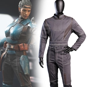 May include: A detailed image showcases a costume and a figure. The costume features a blue and brown armored top, dark pants, and a brown belt. The figure is wearing a gray jumpsuit with white stitching and black gloves. The overall theme is science fiction.
