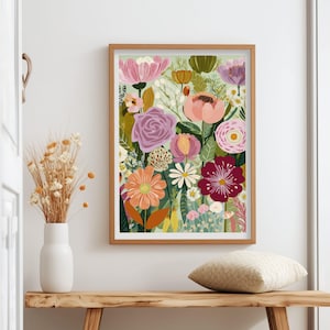 May include: A framed floral art print featuring a vibrant array of flowers in shades of pink, orange, purple, and red. The artwork is displayed on a wooden bench with a white vase holding dried flowers. A decorative pillow rests on the bench.