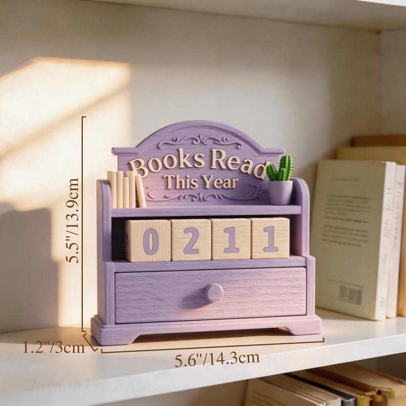 Puede incluir: Un organizador de escritorio de madera lavanda con forma de estanter&iacute;a, con el texto "Books Read This Year". Tiene un caj&oacute;n, una estanter&iacute;a con libros peque&ntilde;os y bloques de madera que muestran "0211". El organizador mide 13,9 cm de alto y 14,3 cm de ancho.