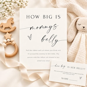 Könnte beinhalten: Eine weiße Spielkarte mit schwarzem Text HOW BIG IS mommys belly und Anweisungen für eine Babyparty-Aktivität. Eine kleinere passende Karte zeigt how big IS HER BELLY? Ein hölzernes Schaukelpferd-Spielzeug und ein beiges Plüschkaninchen sind zu sehen.