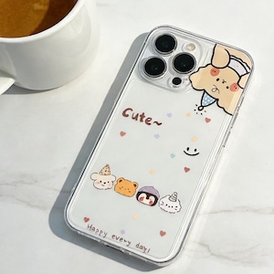 May include: Clear phone case with a cute cartoon design. The case features the text "Cute~" and "Happy every day!" along with illustrations of a dog, bear, penguin, and other characters. The case is designed to fit a smartphone.