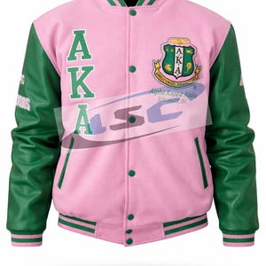 May include: Pink and green varsity jacket with the letters "AKA" in green on the front. The jacket has green leather sleeves and a green collar and trim. A crest is on the chest, and the words "Alpha Kappa Alpha Sorority, Inc." are printed on the jacket.