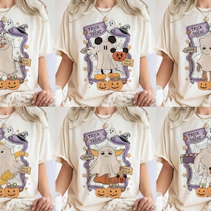 May include: Cream-colored t-shirts with Halloween-themed graphics. Each shirt features a different cartoon character dressed as a ghost, surrounded by pumpkins, a spider web, and the words "Trick or Treat".