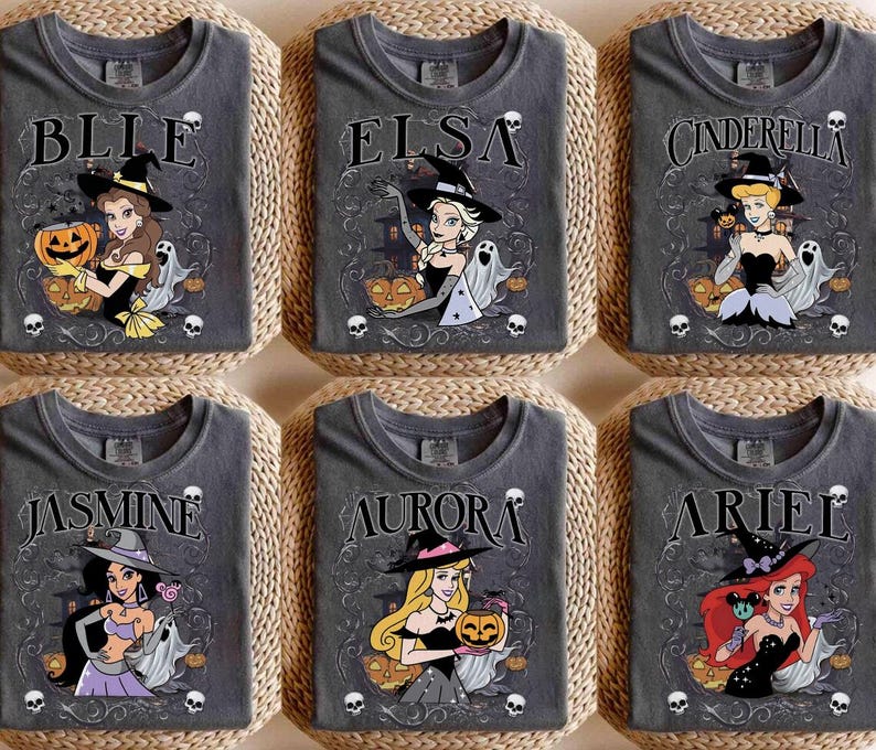 May include: Six charcoal grey t-shirts featuring Disney princesses dressed as witches for Halloween. Each shirt displays a character name, a princess in a witch hat, a pumpkin, ghosts, and skulls. The designs include Belle, Elsa, Cinderella, Jasmine, Aurora, and Ariel.