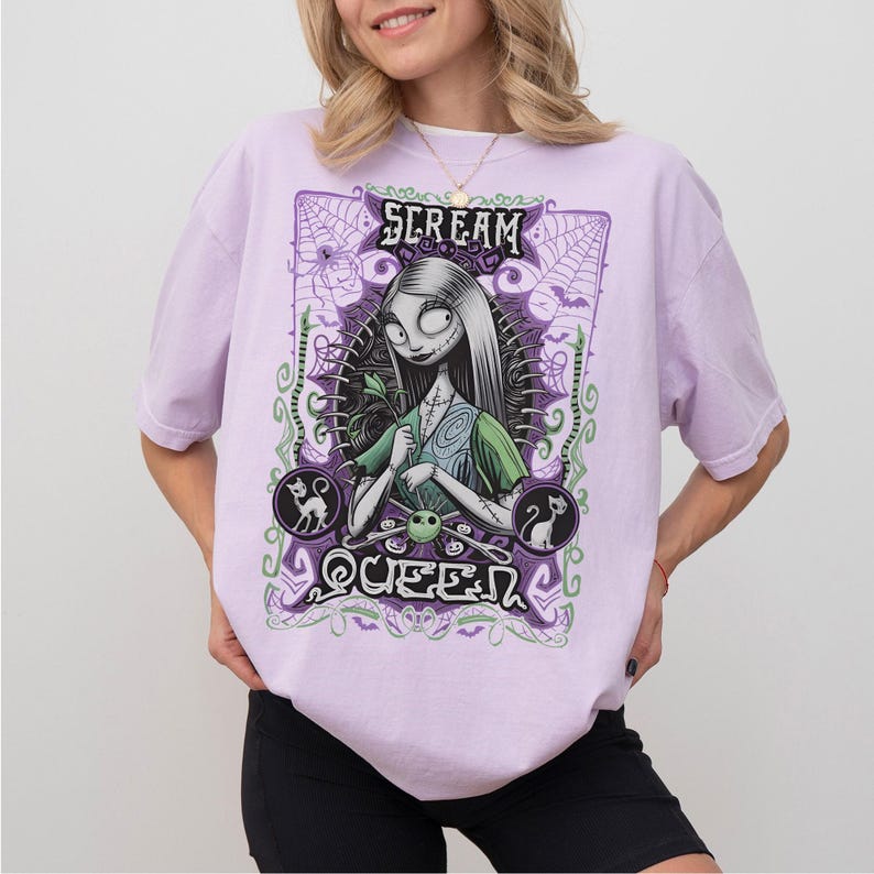 K&ouml;nnte beinhalten: Helllila T-Shirt mit einem Aufdruck von Sally aus The Nightmare Before Christmas. Das Design enth&auml;lt den Text "SCREAM QUEEN" in einem dekorativen Rahmen mit Flederm&auml;usen, Katzen und Spinnweben. Das T-Shirt hat kurze &Auml;rmel.