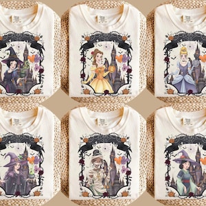 May include: Six off-white t-shirts featuring graphic prints of various animated characters in Halloween-themed attire. Each design includes a dark castle background, spiderwebs, pumpkins, and colourful balloons framed by thorny vines and roses.