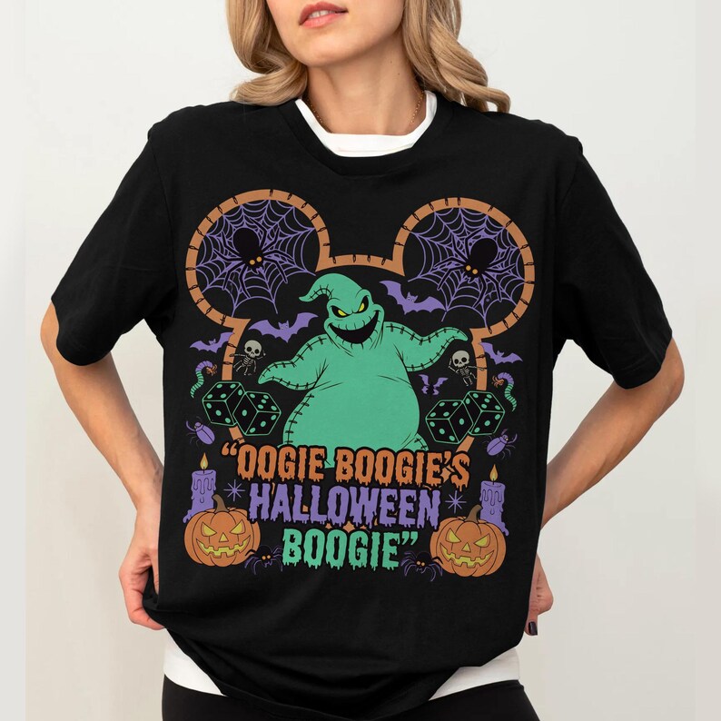 May include: Black t-shirt featuring a green Oogie Boogie character design. The design includes purple bats, spiderwebs, dice, and the text "Oogie Boogie's Halloween Boogie". The shirt has a white collar.