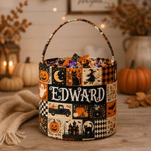 May include: A cylindrical Halloween candy bucket with a handle, featuring a patchwork design of pumpkins, black cats, a witch, a truck, and a haunted house. The name Edward is printed in white lettering across the center of the bucket.