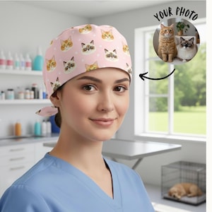 May include: A pink surgical scrub cap with a repeating pattern of cat faces in various colors. The cap is tied in the back. The person in the image is wearing a blue scrub top. A circular image in the background says "YOUR PHOTO".