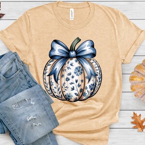 “Pumpkin Season shirt in soft cream, cozy fall graphic design.”
