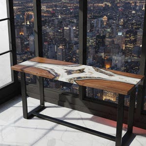 May include: A contemporary console table featuring a live edge wooden top with a white and gold epoxy river design. It has a black metal base. The table is approx. 122 cm long, 41 cm wide, and 76 cm high.