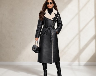 May include: A long black double-breasted coat with a cream-colored faux fur lapel and lining, featuring a matching tie belt at the waist. The coat is worn over a black turtleneck, paired with black knee-high boots and a small black quilted handbag.