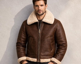 Puede incluir: Una chaqueta de cuero marrón con cuello y puños de piel sintética color crema. La chaqueta cuenta con un cierre de cremallera central de metal, dos bolsillos delanteros inclinados y un corte estructurado con mangas largas.