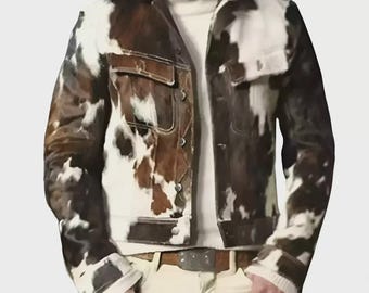 May include: A jacket featuring a brown and white cowhide pattern with a pointed collar, long sleeves, and two chest pockets with flaps. The jacket is worn over a white turtleneck sweater and paired with white trousers and a brown leather belt.