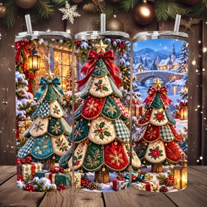 Peut inclure: Trois gobelets cylindriques avec pailles, chacun arborant un motif de sapin de Noël composé de pièces de tissu matelassé rouge, vert et blanc, surmonté d'une étoile dorée et d'un nœud rouge, dans un décor de village enneigé.