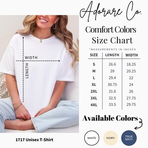 Peut inclure: Un t-shirt unisexe blanc avec un tableau des tailles indiquant les mesures en pouces. Le tableau r&eacute;pertorie les tailles S &agrave; 4XL, avec les mesures de longueur et de largeur correspondantes. Les couleurs disponibles sont le blanc, l'ivoire et le bleu marine. La marque "Adorare Co." est affich&eacute;e.