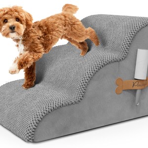 May include: A gray pet step with a textured, knitted top and smooth sides. A small, brown dog is stepping onto the top step. A bone-shaped tag with the word "Pawzy" is attached to the side, along with a lint roller.