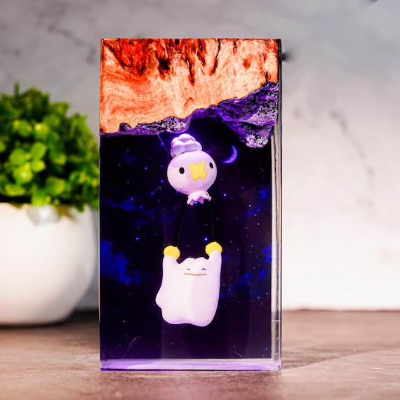 Handmade epoxy-wood resin lamp featuring Drifloon and Ditto in a glowing LED tableau — the kind of Pokémon desk art that stops guests mid-sentence.