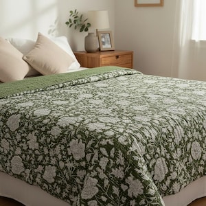 Könnte beinhalten: Ein Bett mit einer grün-weiß gemusterten Steppdecke. Die Steppdecke liegt auf einem Bett mit weißen Laken und zwei beigen Kissen. Der Raum ist gut beleuchtet.