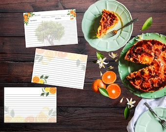 Pode incluir: Vista aérea de uma mesa de madeira com cartões de receitas, fatias de laranja e uma torta em um prato verde. Os cartões de receitas têm ilustrações de laranja e limão. A torta é cortada e tem uma crosta marrom dourada.