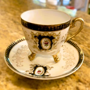 Elegant Gilt-Handle Footed Demitasse Cup & Saucer, Ivory/Cobalt/Gold, Floral Cameo