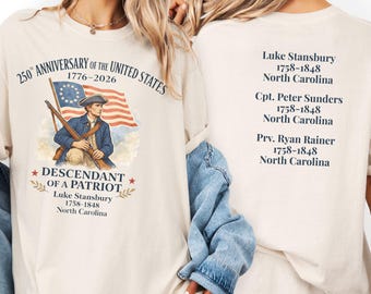 May include: Cream-colored t-shirt with a patriotic design. The front features a Revolutionary War soldier, the American flag, and text commemorating the 250th anniversary of the United States. The back lists names and dates. A casual, historical theme.