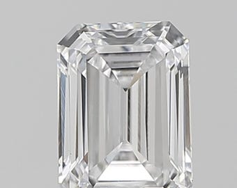 May include: A clear, emerald-cut diamond. The rectangular gemstone has multiple facets that reflect light, creating a brilliant sparkle. The diamond is set against a neutral background, highlighting its clarity and cut. The cut is symmetrical.