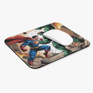 Könnte beinhalten: Ein rechteckiges Mauspad mit einer Comic-Illustration von Superman und Hulk in einer Stadtschlachtszene. Superman trägt einen blauen Anzug mit rotem Umhang, und Hulk ist grün. Eine weiße Computermaus liegt auf dem Pad.