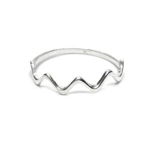 May include: A silver ring with a wavy design. The ring is simple and elegant.
