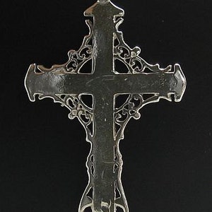 May include: A silver filigree cross pendant with a detailed design. The cross is marked with "925" on the top.