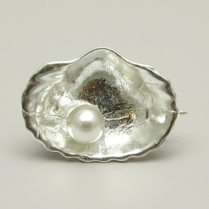 Brosch i sterlingsilver med snäckskal, stämplad 925 med 6 mm odlad pärla