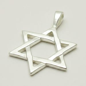 May include: A polished silver-toned Star of David pendant featuring a six-pointed star design with an integrated bail at the top. The pendant has a smooth, reflective metallic surface and a hollow centre, creating a clean and simple geometric shape.