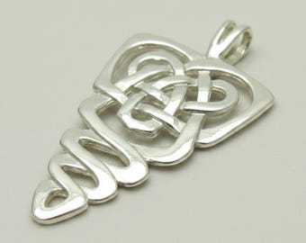 May include: A polished silver pendant featuring an intricate, openwork Celtic knot design. The piece has a tapered, elongated shape with a smooth, reflective metallic finish and a built-in bail at the top for attachment to a chain or cord.