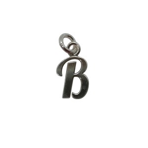 Könnte beinhalten: Ein silberfarbener Metallanhänger in Form des Großbuchstabens B mit einer glatten, polierten Oberfläche und einem runden Biegering an der Oberseite zum Aufhängen. Der Buchstabe ist in einer klassischen, leicht kursiven Schriftart gestaltet.
