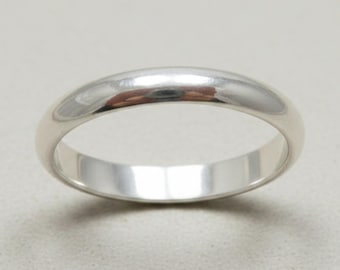 May include: A polished silver-toned metal ring with a smooth, rounded exterior surface and a simple, continuous band design. The ring features a high-shine reflective finish that catches the light, creating a clean and uniform appearance.