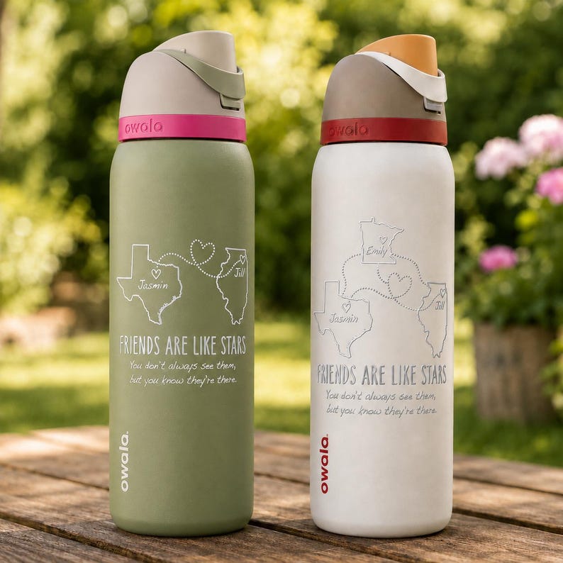 May include: Two insulated water bottles, branded "owala." One is olive green with a pink accent, the other white with a red accent. Both feature a map design and the text "FRIENDS ARE LIKE STARS." Each bottle is approx. 25 cm tall.