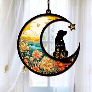 Puede incluir: Una silueta negra de un perro sentado en una luna creciente con un dise&ntilde;o floral. La luna est&aacute; rodeada por un anillo de flores y mariposas. El nombre del perro, "Cupper", est&aacute; escrito en la luna.