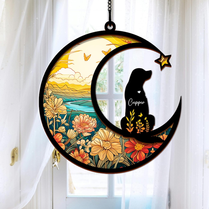 Puede incluir: Una silueta negra de un perro sentado en una luna creciente con un dise&ntilde;o floral. La luna est&aacute; rodeada por un anillo de flores y mariposas. El nombre del perro, "Cupper", est&aacute; escrito en la luna.