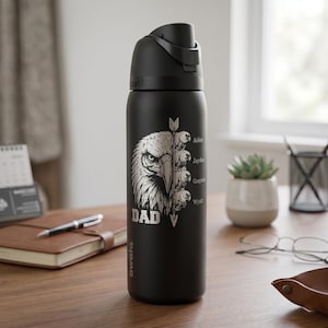 May include: Black insulated water bottle with a silver eagle graphic and the word "DAD". The bottle has a flip-top lid and features the names Aiden, Jayden, Grayson, and Wyatt.