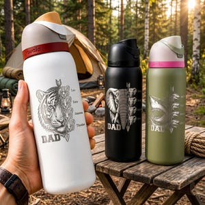 May include: Three insulated water bottles with animal designs. One white bottle features a tiger, the text "DAD", and names. A black bottle has an elephant design, and a green bottle has a shark design. All bottles have a flip-top lid.