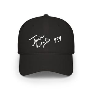 Pode incluir: Um boné de beisebol preto com texto bordado em branco no painel frontal. O texto exibe as palavras Juice WRLD em uma fonte manuscrita estilizada, seguidas pelo número 999. O boné possui uma copa estruturada, aba curva e um botão no topo.