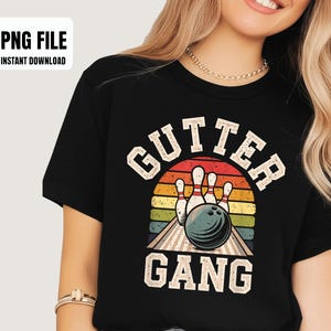 May include: Black t-shirt with a bowling-themed graphic. The design features the words "GUTTER GANG" in a vintage font, along with bowling pins and a ball set against a sunset background. The image also includes the text "PNG FILE INSTANT DOWNLOAD".