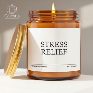 May include: A lit, hand-poured candle in a brown glass jar with a gold lid. The label reads "STRESS RELIEF" and "100% NATURAL SOY WAX". The candle is 9 oz and burns for 40 hours. The brand name is Célestia.