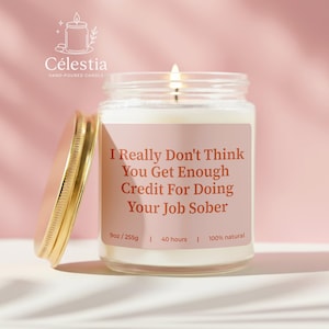May include: A lit, hand-poured candle in a glass jar with a gold lid. The label reads "I Really Don't Think You Get Enough Credit For Doing Your Job Sober." The candle is 9oz and burns for 40 hours.