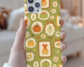May include: A green phone case featuring a repeating pattern of pumpkins, bows, and floral elements in orange, cream, and brown. The case has a glossy finish and a camera cutout.