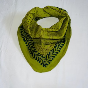 Könnte beinhalten: Ein gefaltetes grünes Bandana mit einem dunkelgrünen und braunen Blumenmuster. Das Bandana ist aus einem weichen Material gefertigt und wird wahrscheinlich um den Hals oder Kopf getragen.