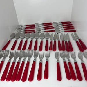 May include: A large flatware set consisting of stainless steel forks, spoons, and knives, all featuring solid red plastic handles. The collection includes multiple pieces of each utensil type, arranged in rows on a plain white surface.