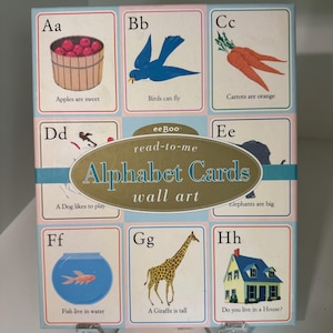 Puede incluir: Juego de tarjetas de pared del alfabeto con ilustraciones coloridas de objetos y animales. Cada tarjeta muestra una letra, una imagen y una frase sencilla. El conjunto incluye tarjetas con manzanas, pájaros, zanahorias, un perro, elefantes, un pez, una jirafa y una casa.